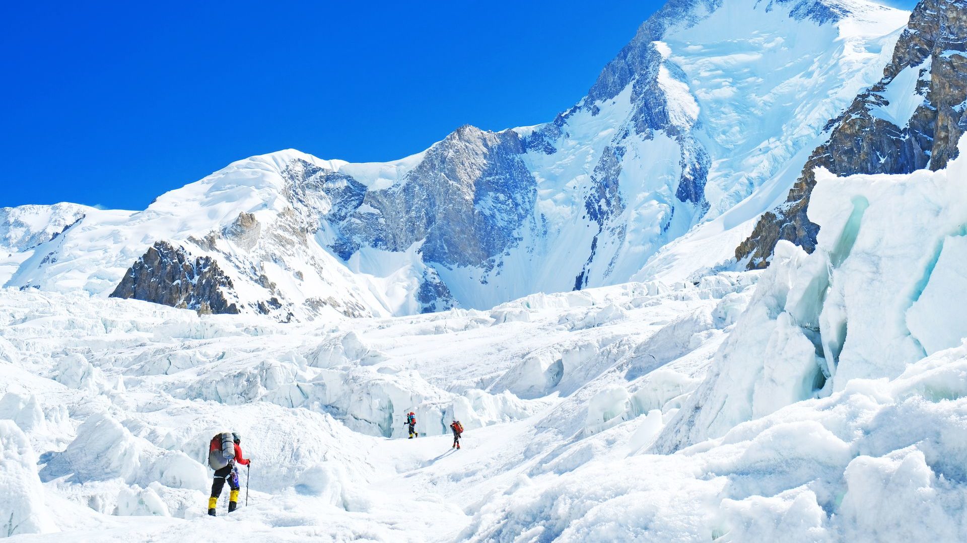 Group,Of,Climbers,Reaches,The,Summit,Of,Mountain,Peak.,Three